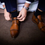 Marié qui noue ses lacets durant ses préparatifs avant de partir pour la mairie