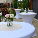 Soliflores avec roses disposés sur des mange-debout pour la décoration du vin d'honneur en terrasse